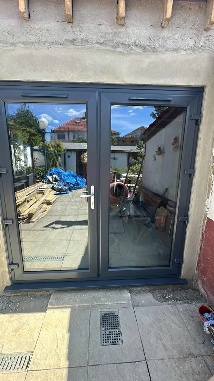 Grey glazed French doors opening onto a patio