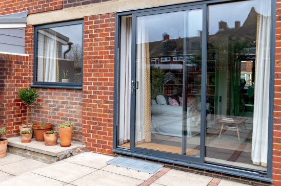 Anthracite grey aluminium sliding patio doors on a modern extension