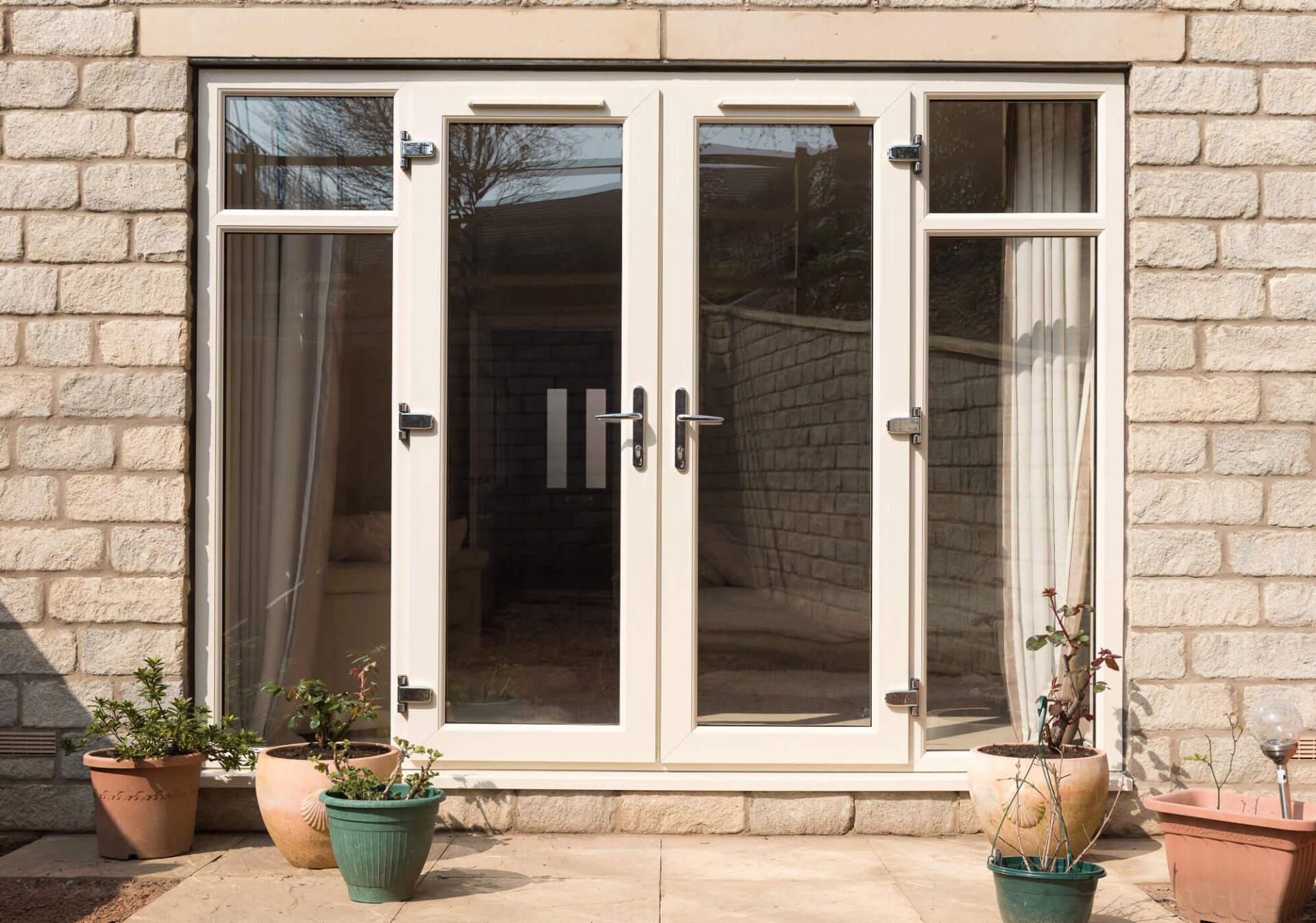 Cream uPVC French doors with side lights on a stone cottage