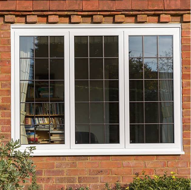 White aluminium windows with leaded glass in a brick property