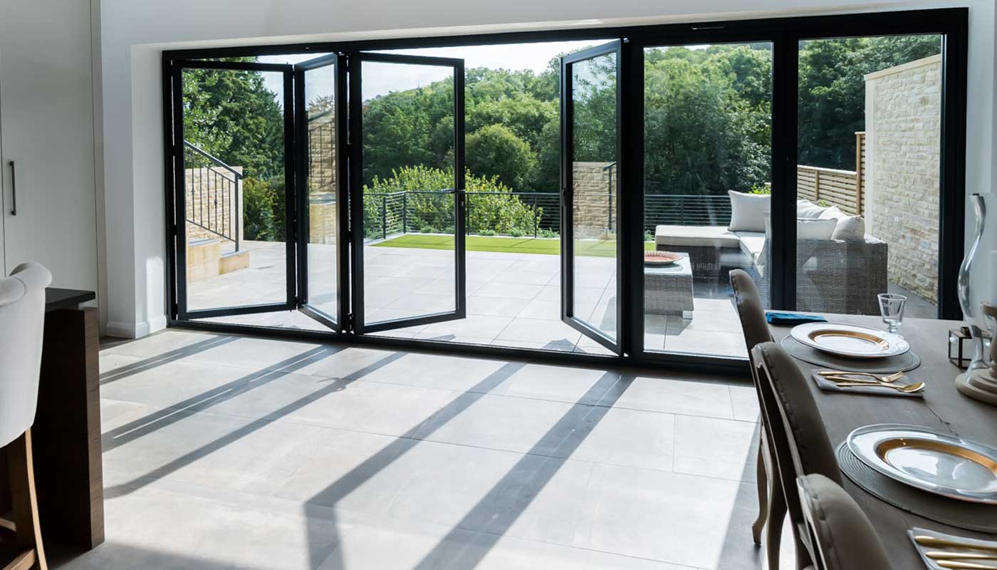 Anthracite grey aluminium bifold doors opening onto a garden terrace