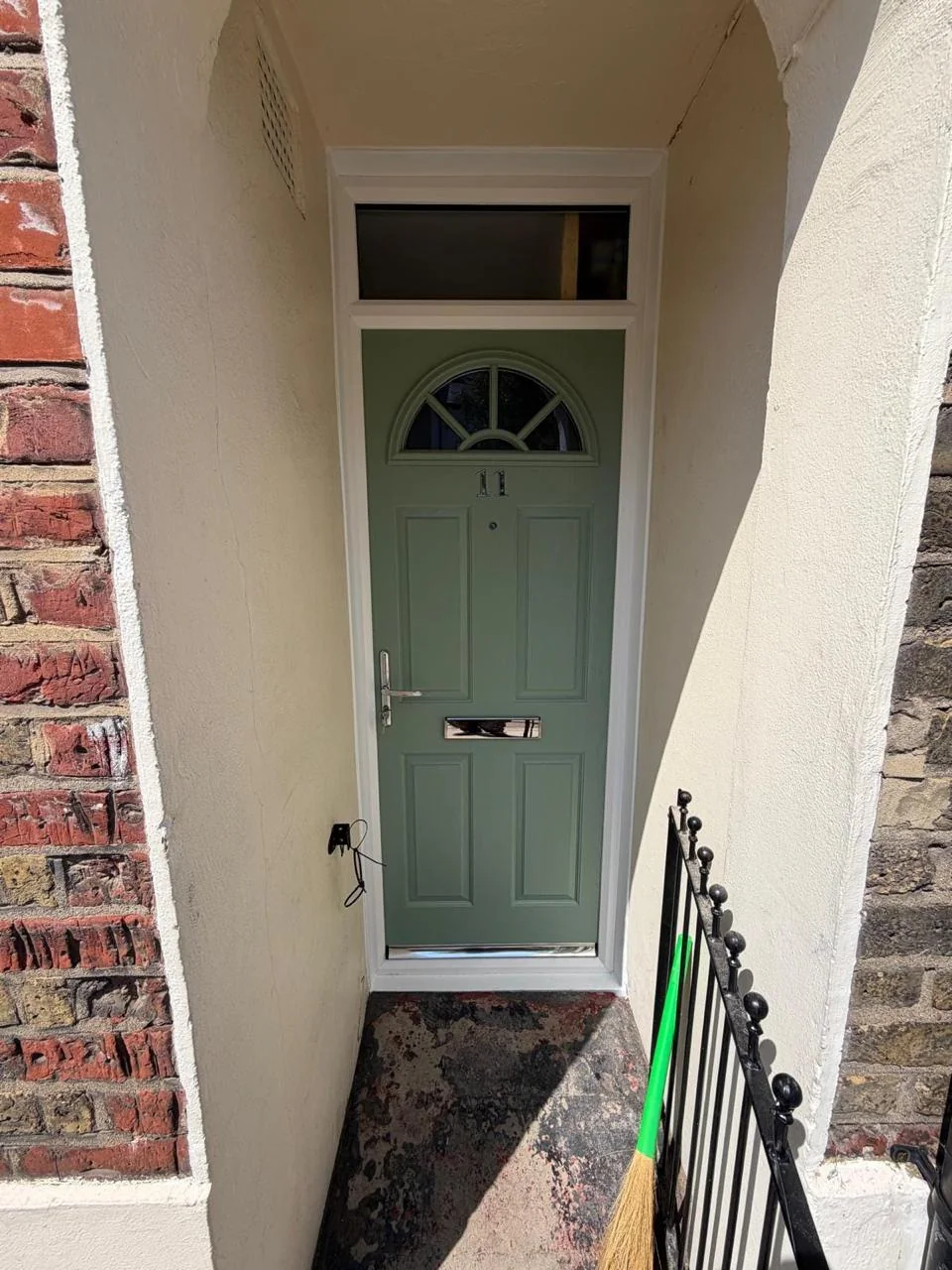 Green composite entrance door with a fanlight and top light