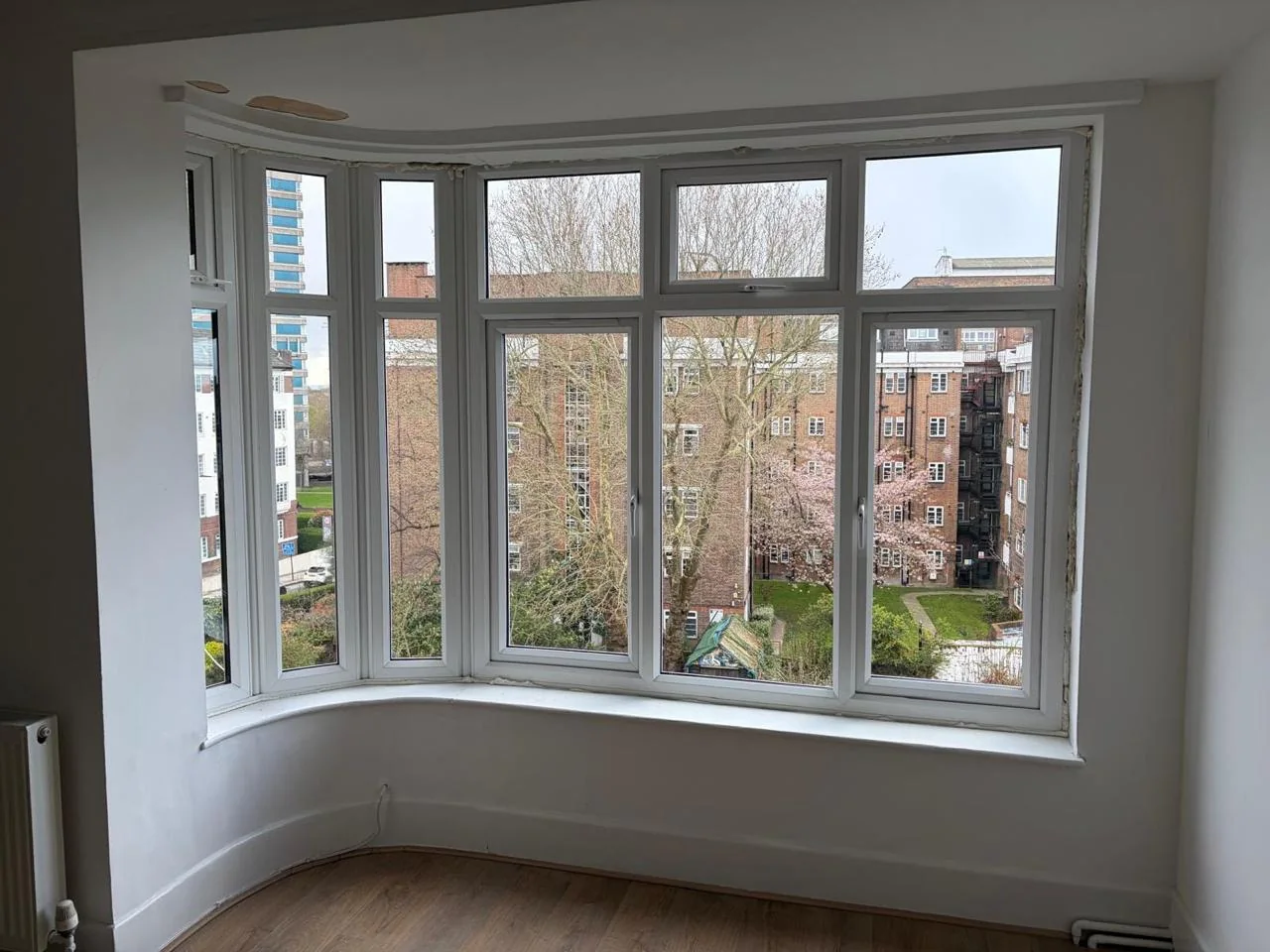 Wide white bay window viewed from a completed interior