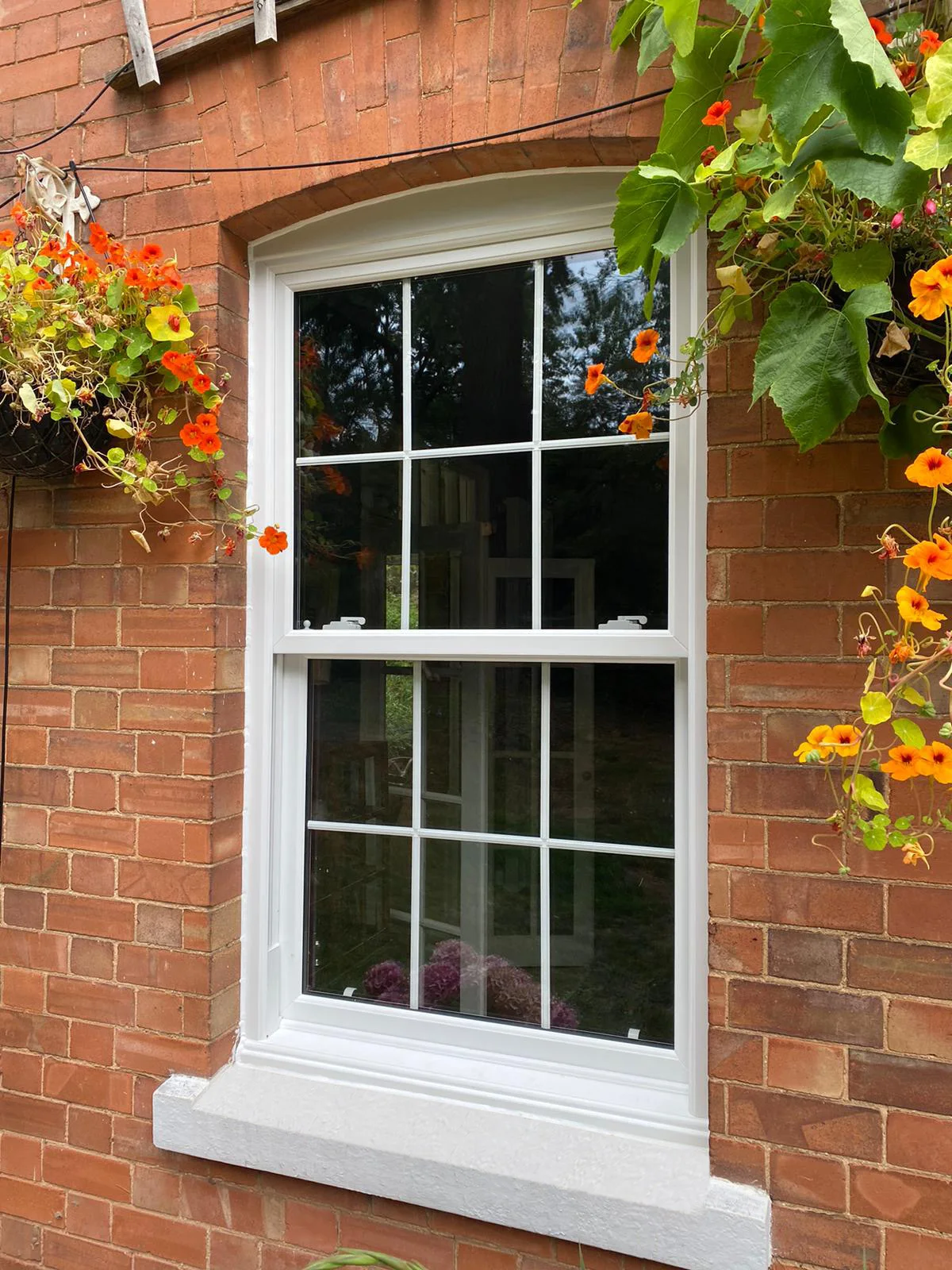 White sliding sash window with Georgian bars in a red-brick wall