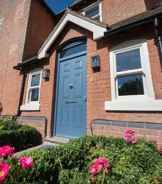 Blue composite front door on a traditional brick home