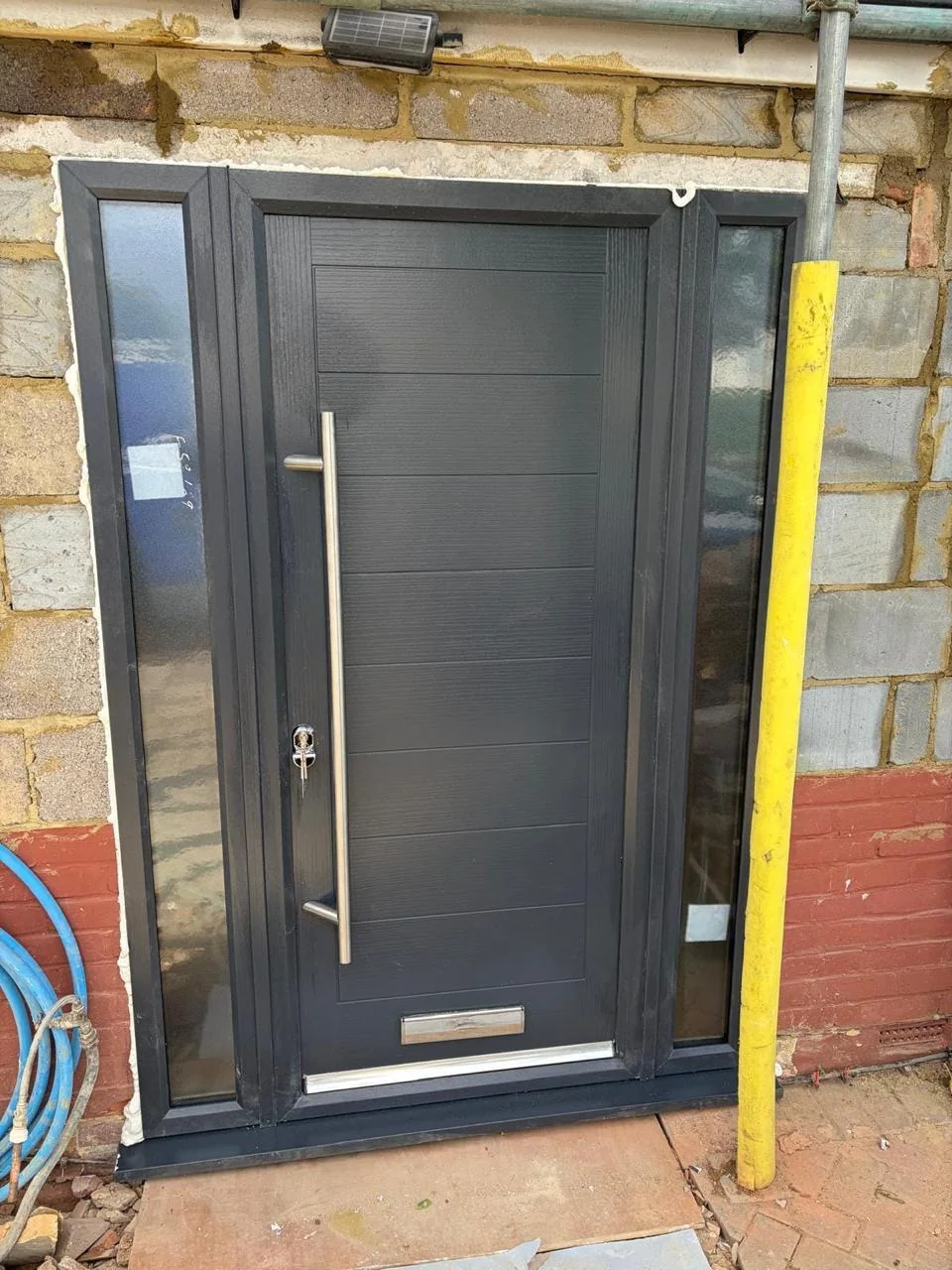Modern dark entrance door with glazed side lights