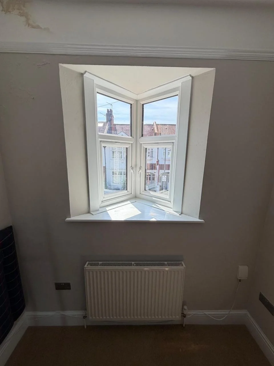 Compact white bay window viewed from inside a completed room