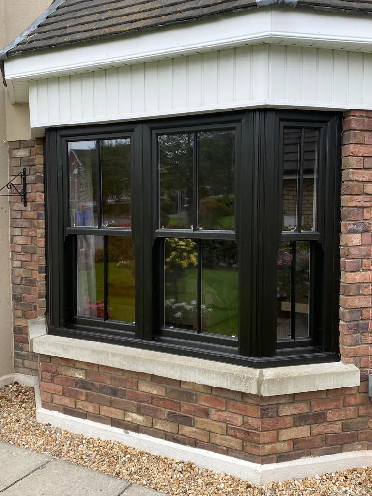 Black vertical sliding sash bay window with Georgian bars