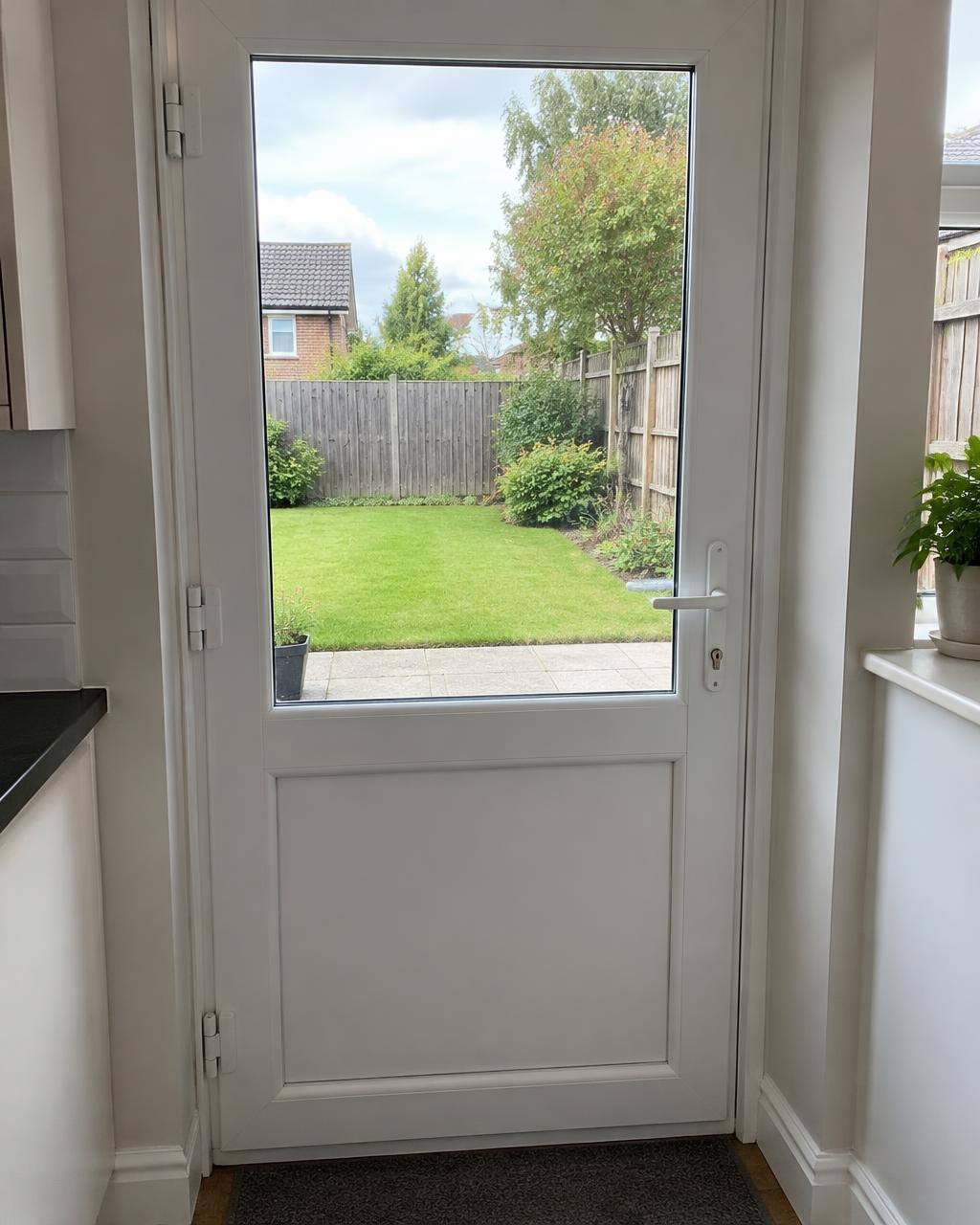 White uPVC back door with glass on the top half and a panel below